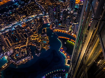 Vibrant aerial cityscape of Dubai at night with illuminated skyscrapers and urban landscape. HD wallpaper