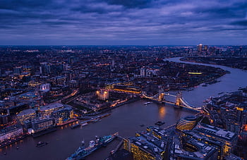 A breathtaking aerial view of London's Tower Bridge and the River Thames illuminated at twilight. HD wallpaper
