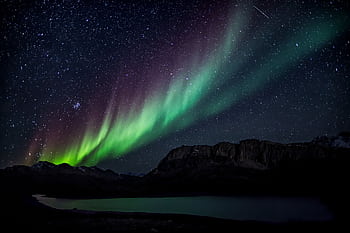 Mesmerizing aurora borealis illuminating the night sky over a serene landscape, capturing nature's beauty. HD wallpaper