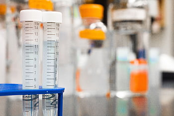 Two clear test tubes in a laboratory, essential for scientific research. HD wallpaper