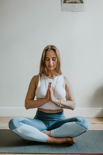 A serene of a woman practicing meditation indoors, promoting mindfulness and wellbeing. HD phone wallpaper