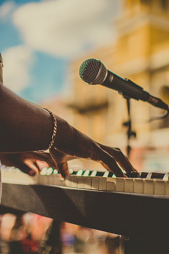 Musician playing piano and singing with a micro outdoors in San Juan. HD phone wallpaper