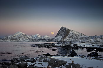 Beautiful twilight view of snow-capped mountains and full moon reflecting on a tranquil lake. HD wallpaper