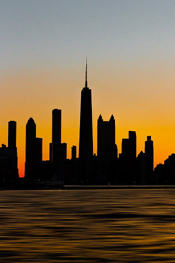 Silhouette of the Chicago skyline against a vibrant sunset, highlighting skyscraper outlines. HD phone wallpaper