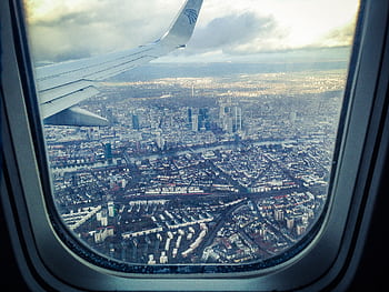 Stunning aerial view of Frankfurt am Main through an airplane window, showcasing the city's skyline and architecture. HD wallpaper