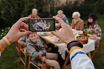 A smart records a multi-generational family enjoying an outdoor meal together. HD wallpaper