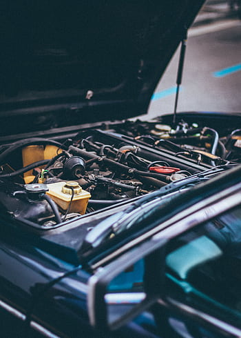 Detailed view of an exposed car engine under maintenance in Barcelona. HD phone wallpaper