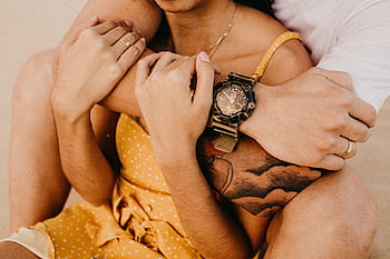 Warm, intimate close-up of a couple embracing, highlighting a stylish wristwatch. HD wallpaper