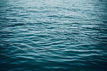 A serene view of blue ocean waves creating a calming texture on the water's surface. HD wallpaper