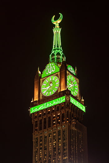 Makkah Royal Clock Tower glowing green against the night sky. HD phone wallpaper
