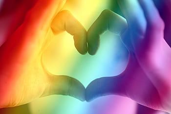 Hands forming a rainbow heart shape, symbolizing love, unity, and LGBTQ pride. HD wallpaper