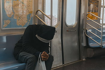 A lone passenger sitting in a New York City subway train, evokes feelings of solitude and reflection. HD wallpaper