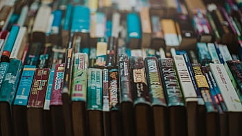 Close-up of various books on a shelf showcasing an array of titles and genres. HD wallpaper