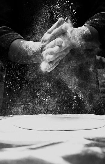 Black and white of a chef clapping flour in a kitchen, creating a dramatic effect. HD phone wallpaper