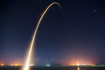 Spectacular long exposure of a rocket launch under a clear, starry night sky showcasing the trail. HD wallpaper