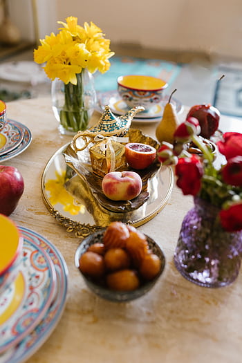 Colorful Eid table with fruits, traditional dishes, and vibrant flowers, beautifully arranged for a festive celebration. HD phone wallpaper