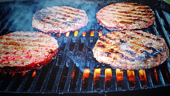 Juicy beef patties cooking on a hot grill, perfect for barbecue cookouts. HD wallpaper