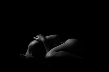 Artistic black and white nude graph featuring a silhouette of a woman in a studio. HD wallpaper
