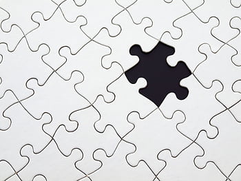 Close-up of an incomplete white puzzle with one missing piece, symbolizing challenge and strategy. HD wallpaper