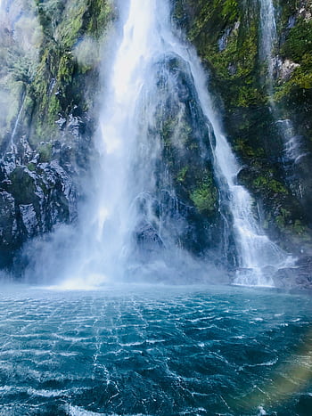 A stunning waterfall cascading into a turquoise pool in Southland, New Zealand. HD phone wallpaper