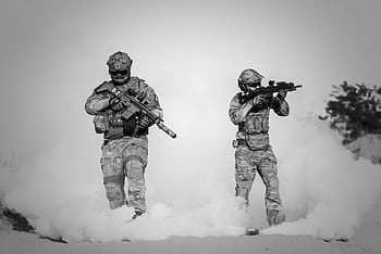 Black and white of soldiers in a tactical operation amidst smoke and sand. HD wallpaper