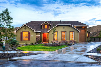 Beautifully illuminated modern home exterior with a lush lawn and wet driveway in Boise, Idaho. HD wallpaper