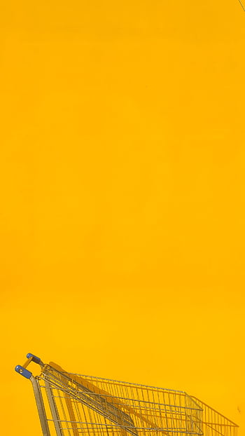 A sleek shopping cart against a vibrant yellow backdrop, perfect for retail themes. HD phone wallpaper