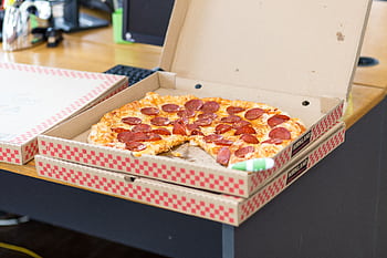 Delicious pepperoni pizza in an open box on a desk, perfect for a quick meal. HD wallpaper
