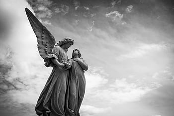 Striking black and white of angelic sculptures under dramatic clouds. HD wallpaper