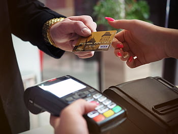 Close-up of a credit card payment being processed at a POS terminal. HD wallpaper