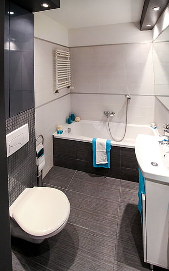 Contemporary bathroom featuring a sleek white bathtub, modern fixtures, and minimalist interior design. HD phone wallpaper