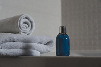 Luxurious white towels and blue bottle create a tranquil spa atmosphere. HD wallpaper