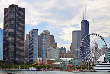 Chicago skyline featuring the iconic Ferris wheel on Navy Pier with skyscrapers like Hancock Tower. HD wallpaper