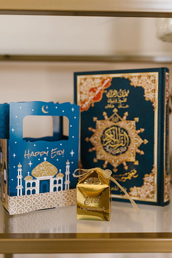 Golden gift box and Quran with decorative Eid-themed packaging for celebration. HD phone wallpaper