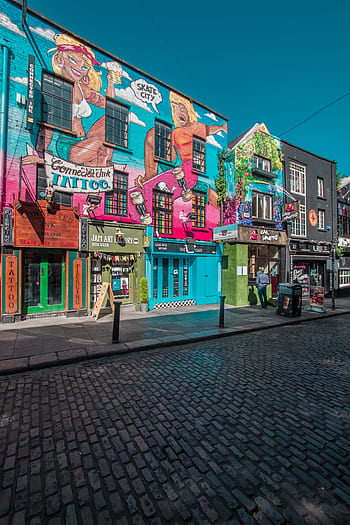 Vibrant street art and shops in a lively Dublin city street. HD phone wallpaper