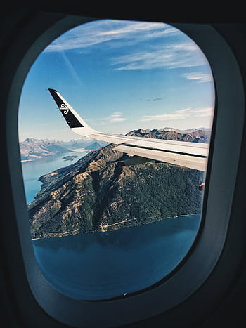 Stunning aerial view of mountains and sea from an airplane window. HD phone wallpaper