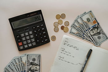 Flat lay of calculator, cash, coins, and handwritten notes for budget planning. HD wallpaper