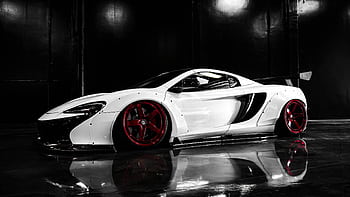 Modern luxury sports car with custom red wheels in a showroom. HD wallpaper