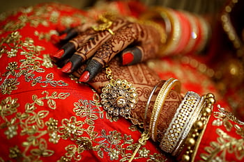 Close-up of ornate henna designs and traditional jewelry on a bride's hands, highlighting Indian wedding elegance. HD wallpaper