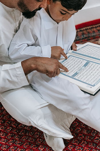 A father and son reading the Quran together, symbolizing faith and tradition. HD phone wallpaper