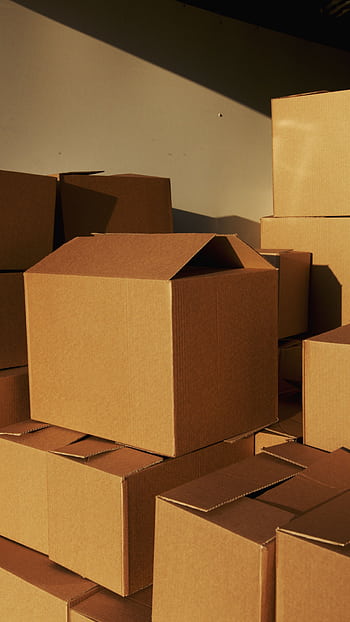 Stacked cardboard boxes ready for shipping or storage in a warehouse setting. HD phone wallpaper