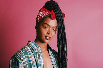 Elegantly posed young woman with braided hair and plaid shirt against a pink background. HD wallpaper