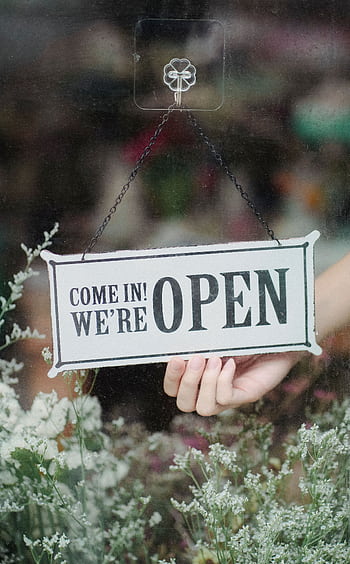 A welcoming open sign in a flower shop window with delicate blossoms in the foreground. HD phone wallpaper