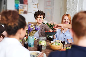 A happy group of friends and family enjoying a meal together indoors. Perfect for themes of togetherness and joy. HD wallpaper