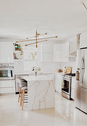 A bright, modern kitchen featuring white cabinetry, stainless steel appliances, and minimalist decor. HD phone wallpaper