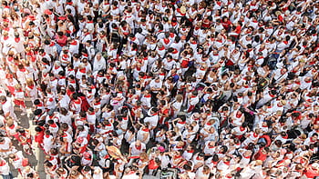High-angle view of a bustling festival crowd dressed in white and red attire. HD wallpaper