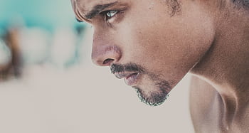 A close-up side view of a young man with a serious and focused expression. HD wallpaper