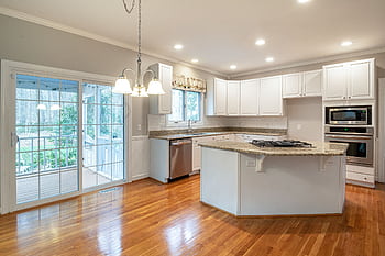 Bright modern kitchen featuring marble island and wooden flooring, ideal for family spaces. HD wallpaper