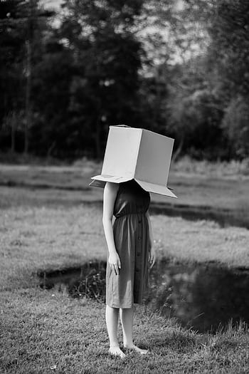 Black and white of a woman outdoors in nature, head hidden in a box. HD phone wallpaper