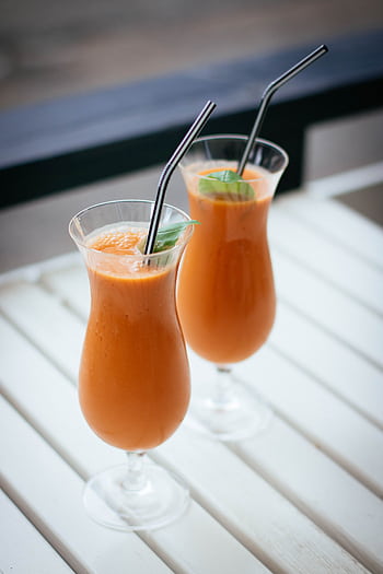 Two tropical smoothies with mint leaves served in tall glasses with straws, perfect for summer. HD phone wallpaper